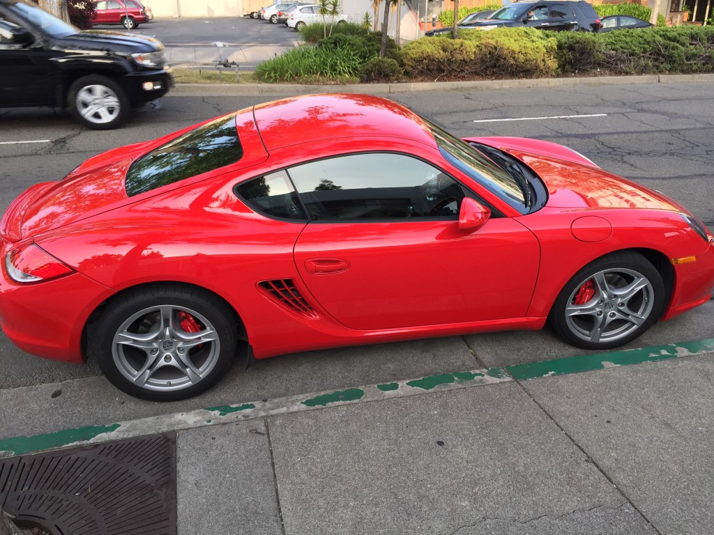 Bright red showy sportscar, parked on the street